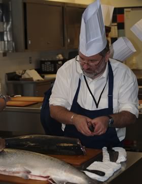 Apprentice Chef Thierry Chopin starting with the head before filleting his salmon.